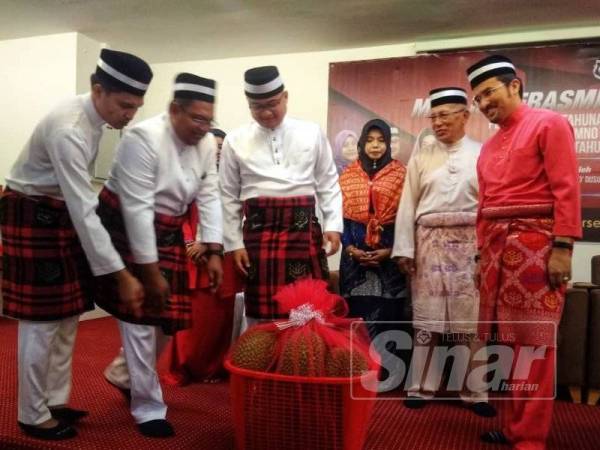 Asyraf Wajdi (kanan) ceria ketika menerima cenderamata daripada Fazli (tiga dari kiri) sempena perasmian berkelompok UMNO Bahagian Raub di sini hari ini.
