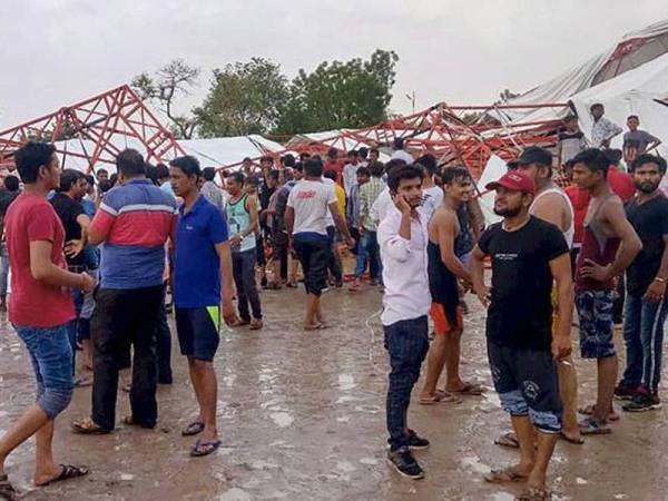 Orang ramai menanti pihak berkuasa melakukan operasi menyelamat di bawah runtuhan. Foto: The Indian Express