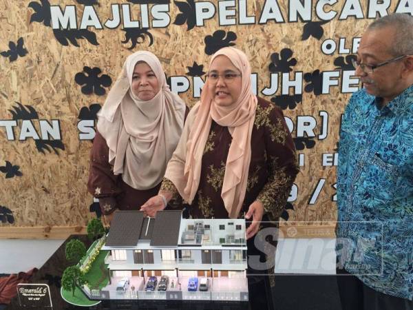 Kamarulzaman (kanan) bersama Norida (kiri) melihat Felina (tengah) menerangkan mengenai rumah contoh Emerald 6 pada majlis tersebut di sini, hari ini.