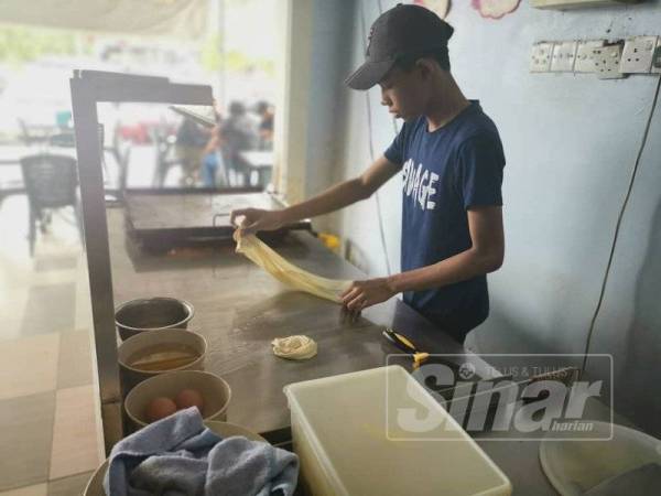 Mohd Adam tidak menjadikan umur muda sebagai penghalang buatnya menyediakan roti canai di restoran milik keluarganya itu