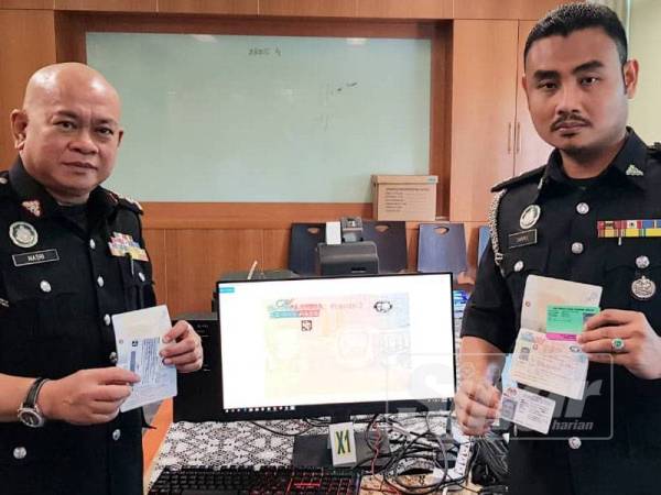 Pegawai Imigresen Kuala Lumpur menunjukkan antara dokumen dan barang yang dirampas dalam operasi itu di sebuah kondominium di Jalan Chow Kit, Kuala Lumpur, semalam.