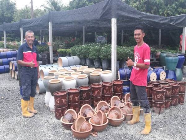 Faizal (kanan) bersama bapanya Jamaludin di hadapan nurseri di Kampung Parit Mesjid. 