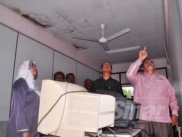 Aminolhuda (kanan) melihat atap siling di makmal komputer di SK Sawah Baru Labis ketika melakukan tinjauan di sekolah tersebut kelmarin. 