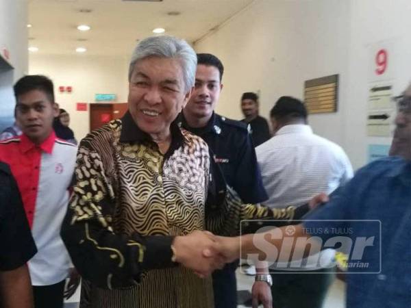 Ahmad Zahid bermesra dengan penyokongnya di mahkamah hari ini.