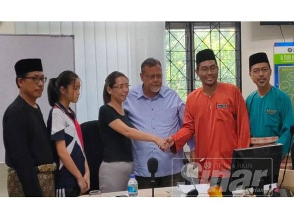 Ibu kepada pelajar berkenaan (tiga,kiri) bersalaman dengan guru berkenaan sambil diperhatikan Aminolhuda ketika pertemuan mereka di Pejabat PPD Johor Bahru, hari ini.