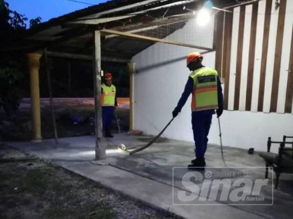 Anggota Angkatan Pertahanan Awam daerah sedang menangkap ular tedung selar di Kampung Parit Rambai di sini semalam.