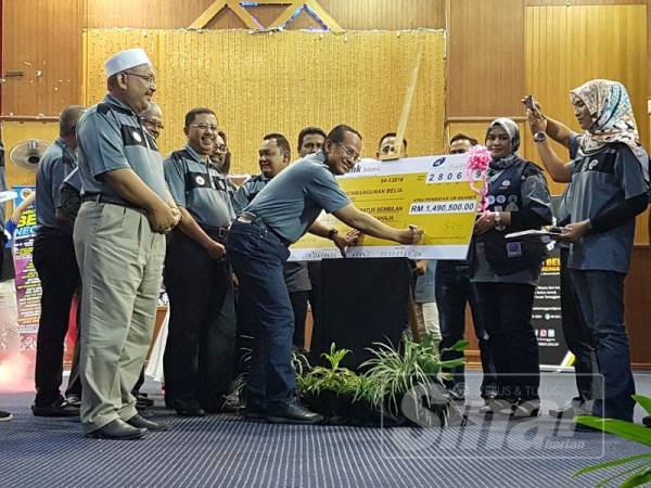 Ahmad Samsuri menurunkan tandatangan pada replika cek kepada Tabung Pembangunan Belia Terengganu sempena Majlis Sambutan Hari Belia Negeri Terengganu di Dewan Berlian Utama MPK.