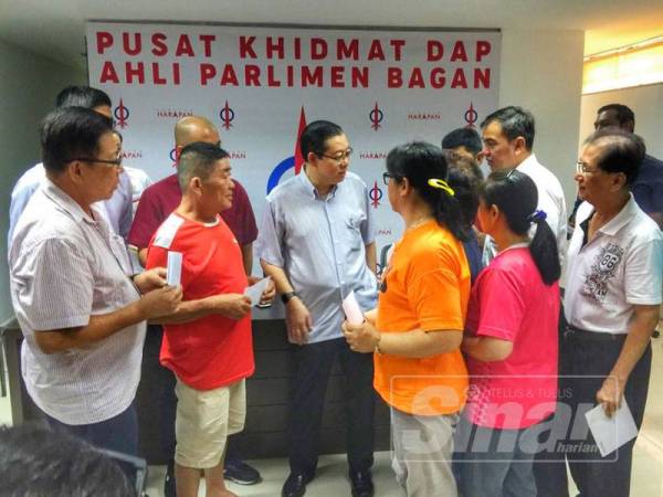 Guan Eng (tengah) beramah mesra dengan penduduk Parlimen Bagan selepas menyampaikan bantuan bencana kepada mereka tadi.