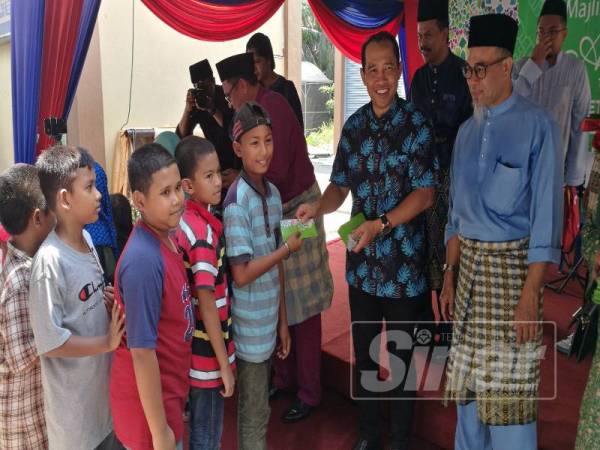 Shahril (kiri) memberi taklimat kepada Abdul Yunus (kanan) mengenai perkembangan projek kajian pemuliharaan kelip-kelip dan habitat di Kampung Dew, hari ini.