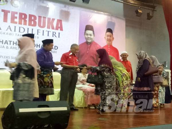 Dr Mahathir menyampaikan sumbangan kepada bomoh patah, tok imam dan penggali kubur di sekitar Langkawi pada Majlis Rumah Terbuka Hari Raya Aidilfitri Parlimen Langkawi di Kompleks Sukan Lada, di sini hari ini.