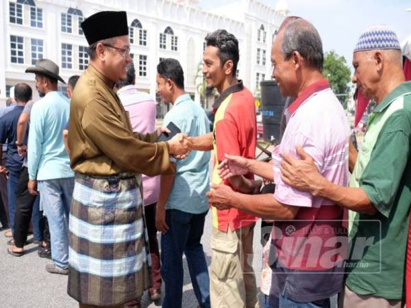 Amzad (kiri) bersalaman bersama tetamu yang hadir sempena Sambutan Hari Raya Aidilfitri peringkat Parlimen Kuala Terengganu di sini.