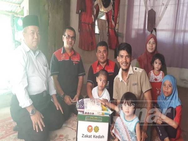 Mohd Nazry (tengah) bergambar bersama Pegawai Zakat Baling, Ahmad Mustaqim Zainul Abidin dan keluarga Nurul Qaisara.