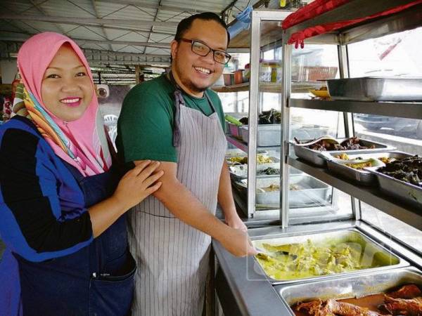 Sukardi (kanan) dan Sulastri menunjukkan hidangan yang terdapat di kedai mereka.