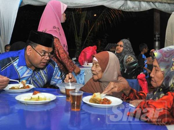 Lokman (kiri) melayan tetamu yang hadir ke Majlis Rumah Terbuka Aidilfitri UMNO Cawangan Bandar Sri Gading, Batu Pahat, di sini malam tadi.