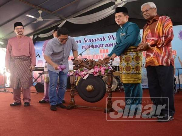 Md Farid (dua dari kanan) menyaksikan Ahmad Faizal memalu gong sebagai gimik perasmian.