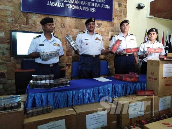 Pannir Selvan (dua, kiri) bersama anggota menunjukkan sebahagian rokok yang dirampas.