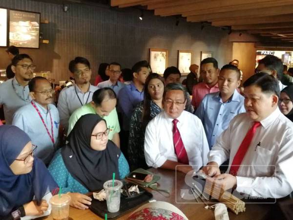 Loy Sian (kanan) memberikan straw buluh kepada orang awam pada program tinjauan hari pertama Kempen Bebas Straw Plastik di Plaza Shah Alam hari ini.