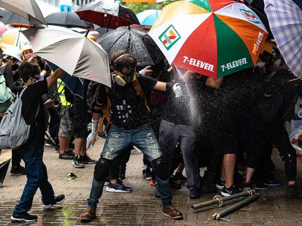 Kumpulan penunjuk perasaan cuba memecahkan tingkap ibu pejabat kerajaan di Hong Kong semalam. - Foto: AFP