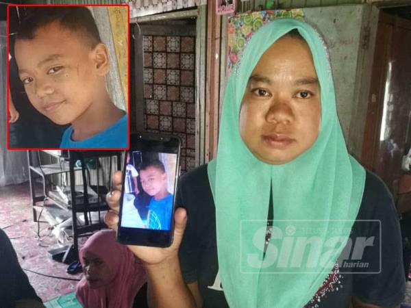 Siti Ruziana menunjukkan gambar anak lelaki yang hilang sejak semalam.