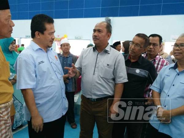 Azman (dua kiri) sempat bertanyakan sesuatu kepada Ketua Pengarah Lembaga Kemajuan Ikan Malaysia (LKIM, Jamaluddin Othman (tiga kiri) yang turut hadir ke Jamuan Aidilfitri LKIM di Kuala Kedah, semalam.