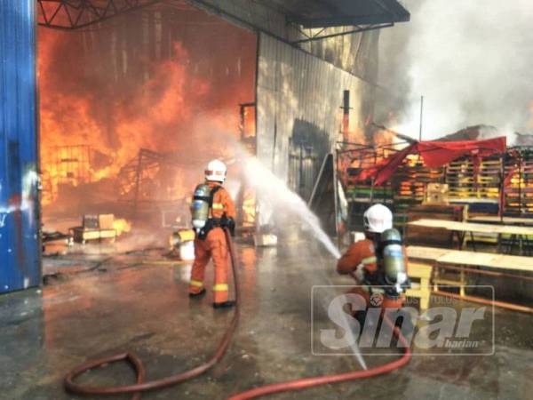 Anggota bomba bertungkus-lumus memadamkan api kebakaran di premis kilang perabot terbabit yang terletak di Kampung Paya Jaras Dalam.