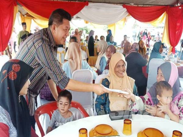 Sazmi menyampaikan sumbangan zakat kepada golongan yang memerlukan di Majlis Sambutan Aidilfitri, di Kesedar Paloh 2.