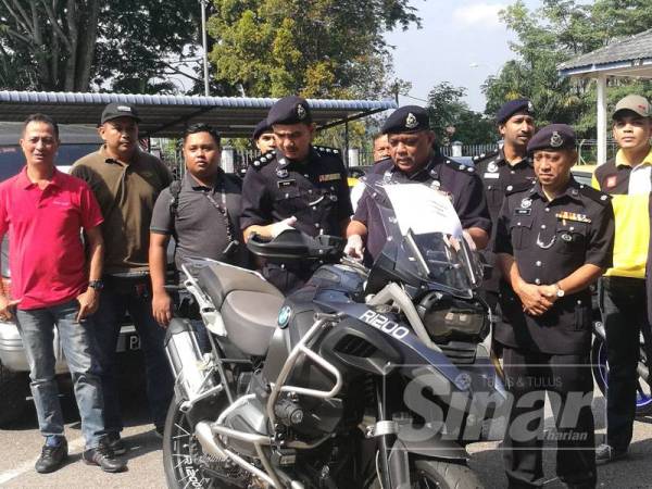 Mohd Yusuf (tengah) menunjukkan motosikal BMW yang dirampas hasil penangkapan tiga ahli geng Che Mie pada 1 Julai lalu.