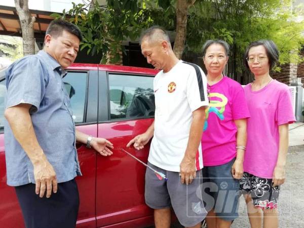 Theam Lye (tiga dari kanan) menunjukkan kepada Chong Siang anak panah yang menembusi keretanya.