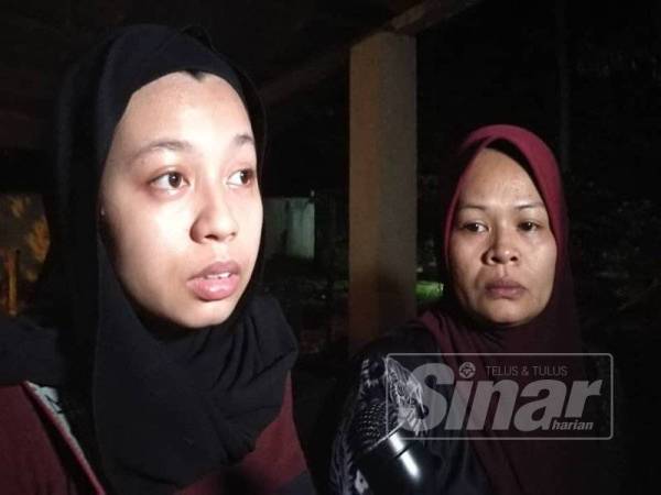 Wan Nur Fazrin Amira (kiri) dan Nik Hasmani ketika ditemui di Tanah Perkuburan Islam Bukit Baka malam tadi.