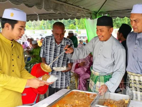 Ahmad Fadhli (dua dari kanan) melayan tetamu yang hadir ke rumah terbuka Aidilfitri di Madrasah Nasrullah, Meranti.