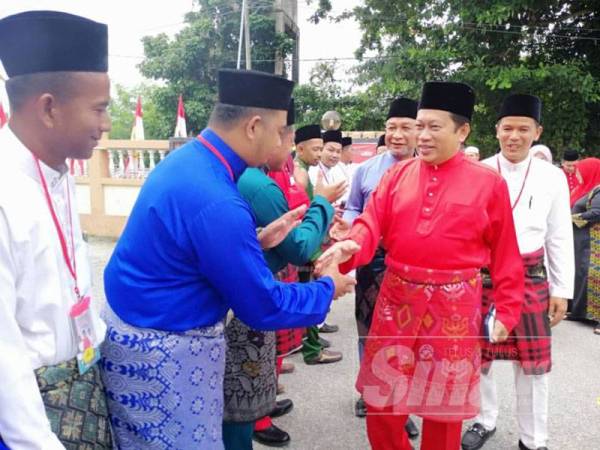 Ahmad diiringi Rosdi (kanan) dan Zulkifli (dua dari kanan) bersalaman dengan perwakilan Pemuda UMNO Tumpat sebaik tiba di pekarangan Dewan Tanjung Che Mas.