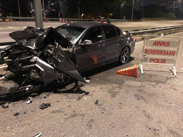 Keadaan kereta jenis Proton Perdana yang remuk selepas merempuh sekatan jalan raya awal pagi tadi.