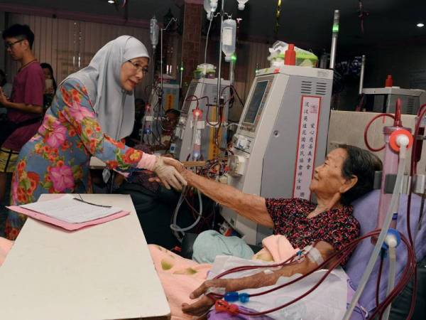 Dr Wan Azizah bersalaman dengan warga emas, Tan An Nya,81, yang melakukan hemodialisis pada lawatan di Pertubuhan Hemodialisis Seberang Perai Selatan hari ini. -Foto Bernama