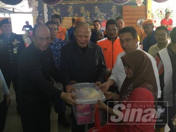 Mohd Khalil dan Adly menyampaikan bantuan kepada mangsa banjir di SK Belimbing Dalam, Durian Tunggal hari ini.