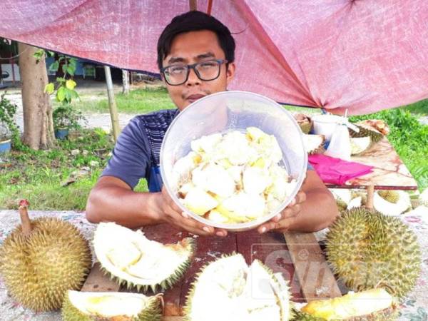 Mohd Izzuwan menunjukkan isi durian yang diletakkan di dalam bekas dan dijual dengan harga RM25 sekilogram mendapat perhatian tinggi.