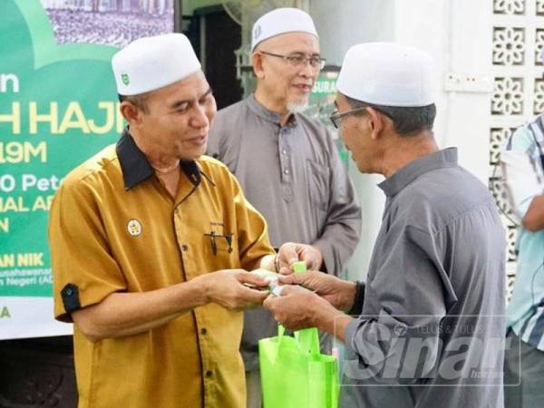 Wan Hapandi menyampaikan sumbangan kepada bakal jemaah haji DUN Sura.