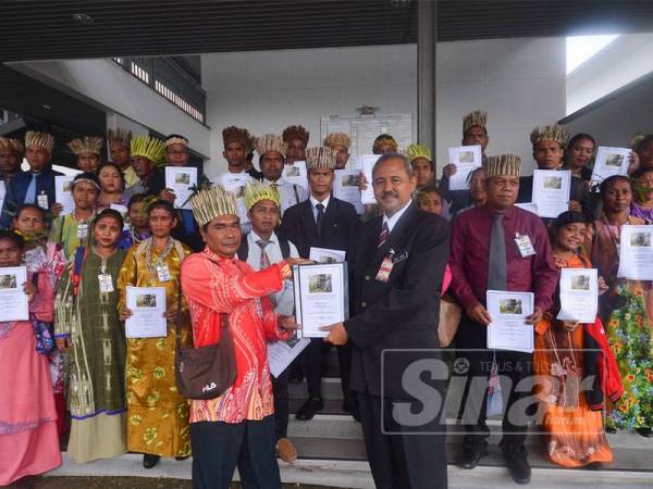 Ketua Pengarah JAKOA, Prof Dr Julie Edo menerima memorandum daripada Tok Batin Kampung Leyep, Baha Busu di Parlimen di sini hari ini. - FOTO SHARIFUDIN ABDUL RAHIM