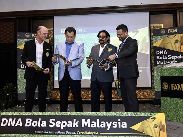 Presiden Persatuan Bola Sepak Malaysia (FAM) Datuk Hamidin Mohd Amin (dua,kiri) bersama Timbalan Presiden FAM, Datuk Seri Subahan Kamal (dua,kanan) melihat buku pada Pelancaran Majlis DNA Bola Sepak Malaysia hari ini. - Foto BERNAMA