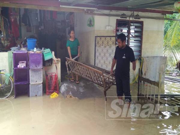 Zuraidi melihat motosikal miliknya yang tidak sempat dialihkan dan mengalami kerosakan teruk akibat banjir.