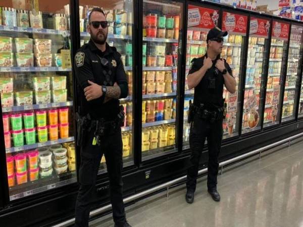 Gambar dua anggota polis terbabit berkawal di hadapan bahagian aiskrim Blue Bell di sebuah pasar raya di Texas menjadi tular di media sosial.