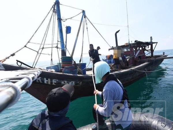 Anggota APMM dan AADK melakukan pemeriksaan di atas sebuah bot nelayan dalam Operasi Khas di Perairan Kuala Kedah, hari ini.