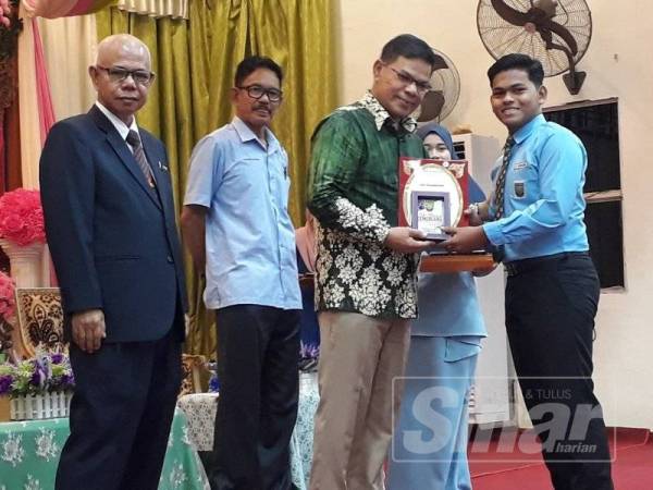 Saifuddin (dua dari kanan) menyampaikan anugerah kepada pelajar pada Majlis Hari Anugerah Kecemerlangan Kali Ke-20 SMK Kuala Nerang semalam.