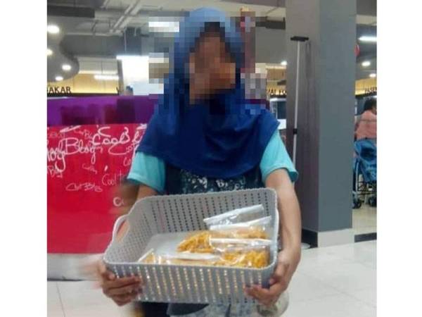 Kanak-kanak berusia 12 tahun ini menjaja makanan ringan di sekitar pasar raya di Bandar Rawang. - Foto: LZS