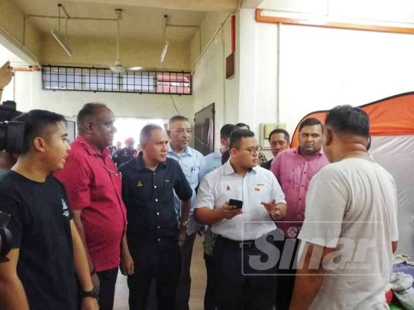 Amirudin (dua dari kanan) meninjau PPS Dewan Serbaguna Kampung Laksamana menempatkan dua keluarga terjejas ribut semalam.