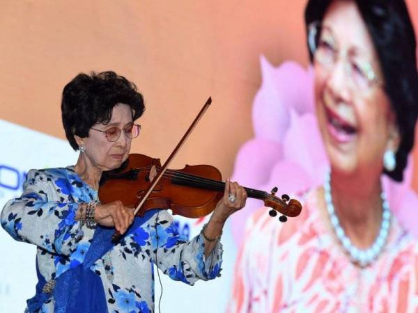 Isteri Perdana Menteri Tun Dr Siti Hasmah Mohd Ali mempersembahkan alunan gesekan biola pada majlis Minum Petang Amal Yayasan Universiti Multimedia di universiti itu hari ini. - Foto Bernama 