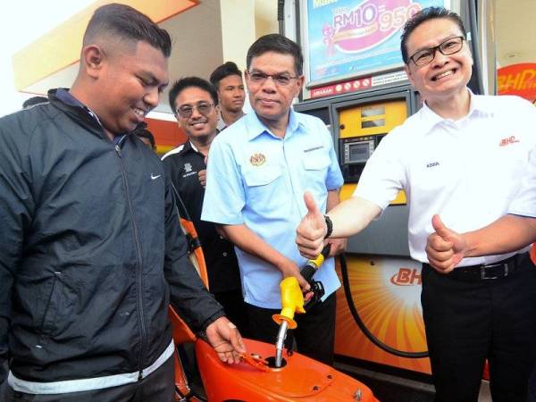 Menteri Perdagangan Dalam Negeri dan Hal Ehwal Pengguna Datuk Seri Saifuddin Nasution Ismail (tengah) mengisi minyak petrol secara percuma kepada penunggang motosikal pada Kempen Kesedaran Keselamatan Petroleum Peringkat Negeri Pulau Pinang hari ini. Foto: Bernama