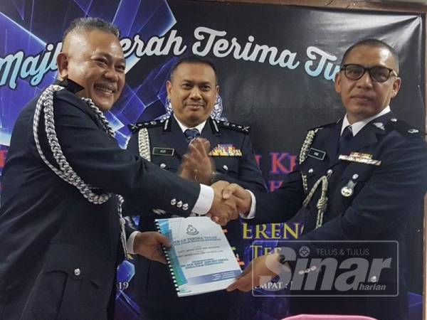 Aidi (tengah) menyaksikan Majlis Serah Terima Tugas Ketua Polis Kemaman antara Mohd Said (kiri) dan Mohd Haki.