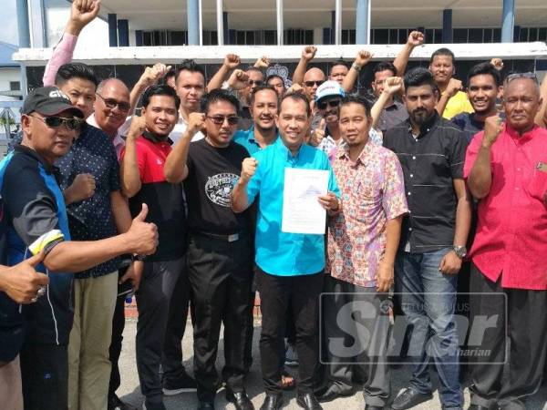 Abdul Yunus (tengah) mengemukakan laporan polis dibuat ke atas pihak didakwa memfitnahnya di pekarangan IPD Kerian, Bagan Serai sambil diiringi lebih 30 penyokong.