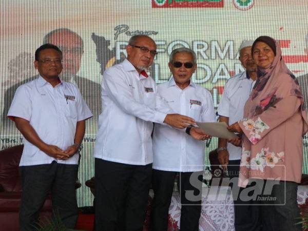  Wan Kharizal menyampaikan sijil Kursus Cerna Mindatani kepada Haslima Romli yang mengikuti seminar pada Program Reformasi Peladang Perlis 2019 semalam, sambil diperhatikan Tengku Aziz (tiga dari kiri).