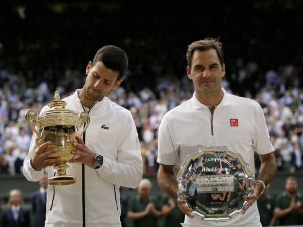 Djokovic (kiri) mempertahankan kejuaraan Wimbledon selepas tewaskan Federer di pentas final. -Foto AP